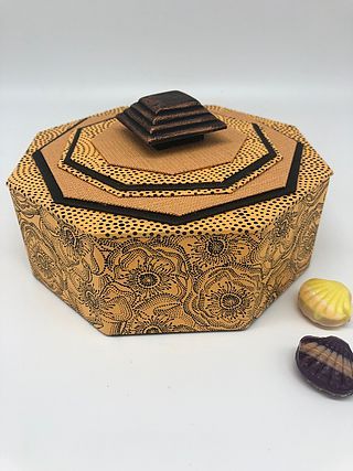 three seashells and a decorative box on a white surface with one shell in the foreground