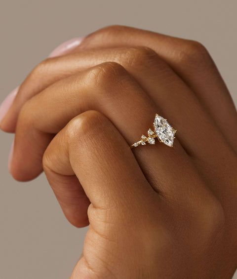 a woman's hand holding an engagement ring with two diamonds on top of it