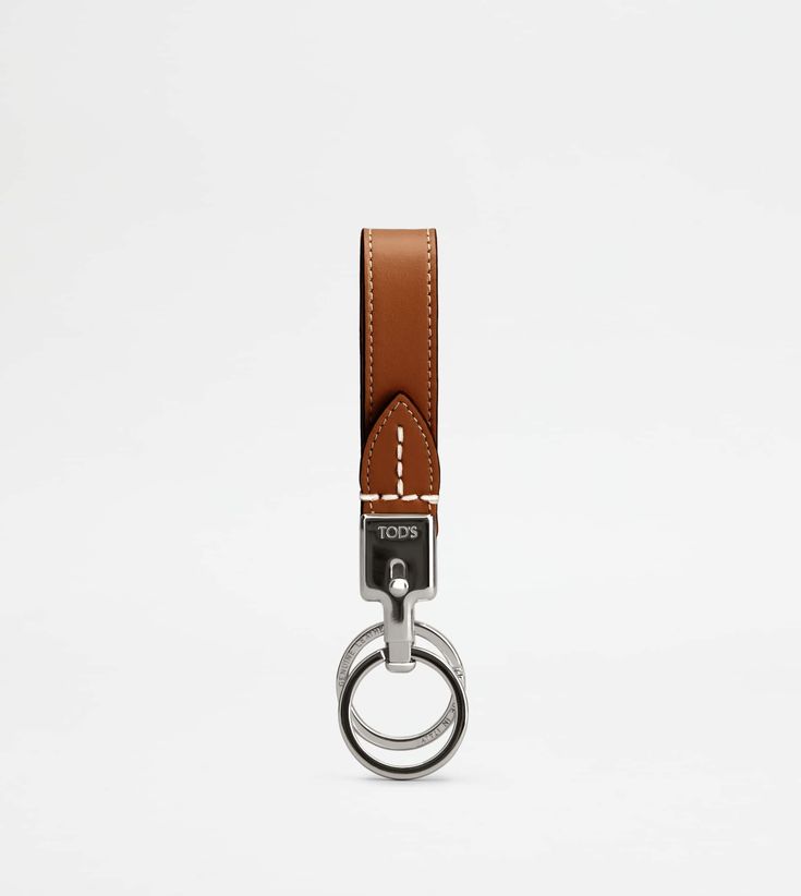 a keychain with a metal ring and brown leather strap hanging from it's side