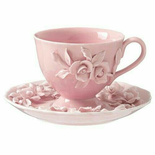 a pink tea cup and saucer with flowers on the side, sitting on a plate