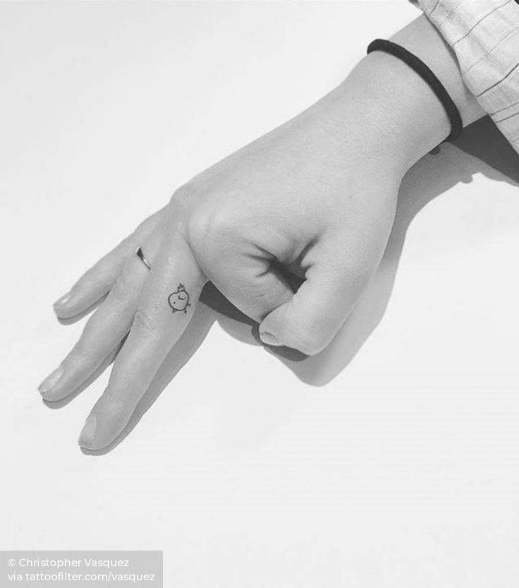 a person's hand with a small tattoo on the middle finger and an apple in the middle