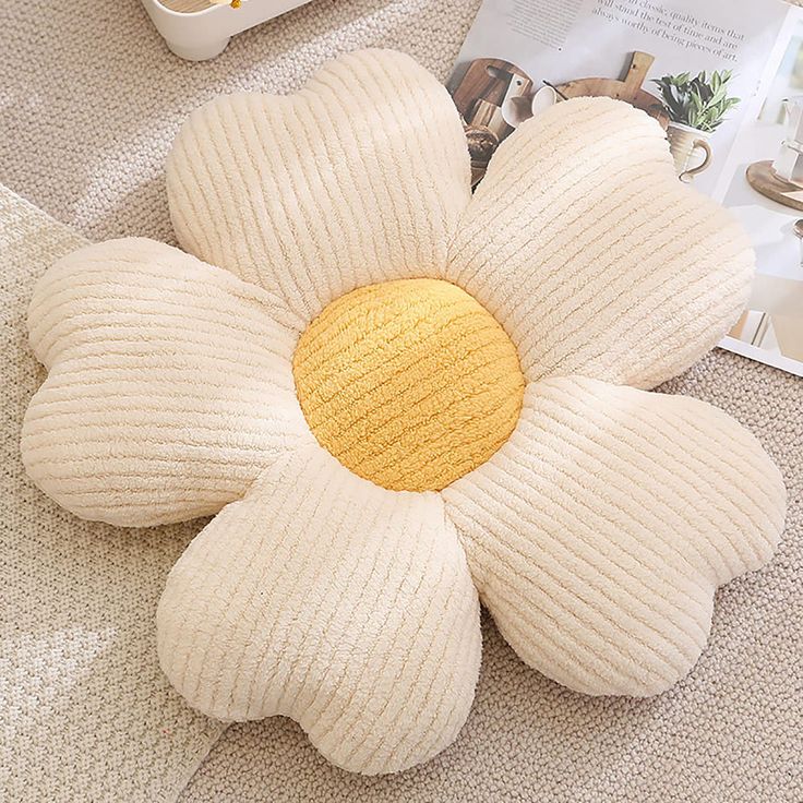 a white flower shaped pillow sitting on top of a table