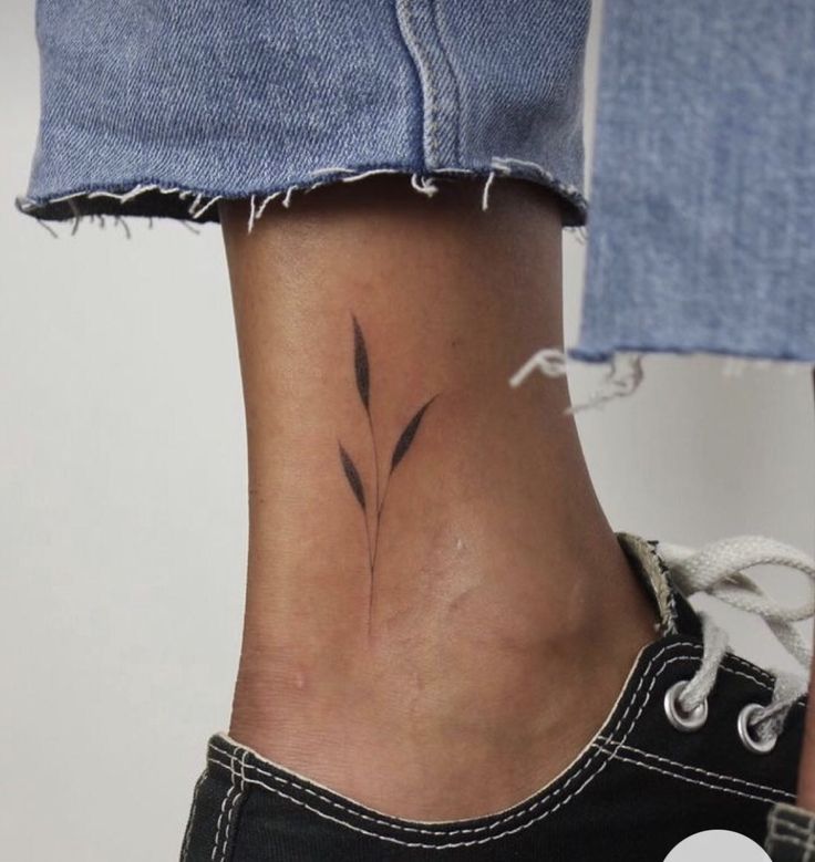 a woman's foot with a small tattoo on the side of her leg,