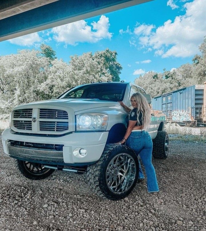 a woman leaning on the hood of a truck