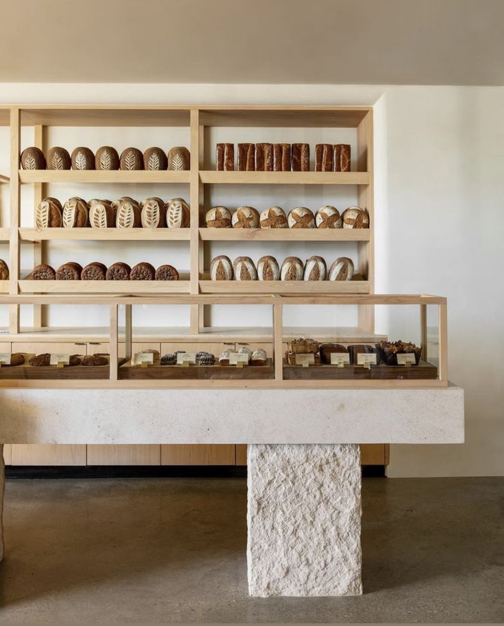 the shelves are filled with different types of breads and pastries on display in an empty room