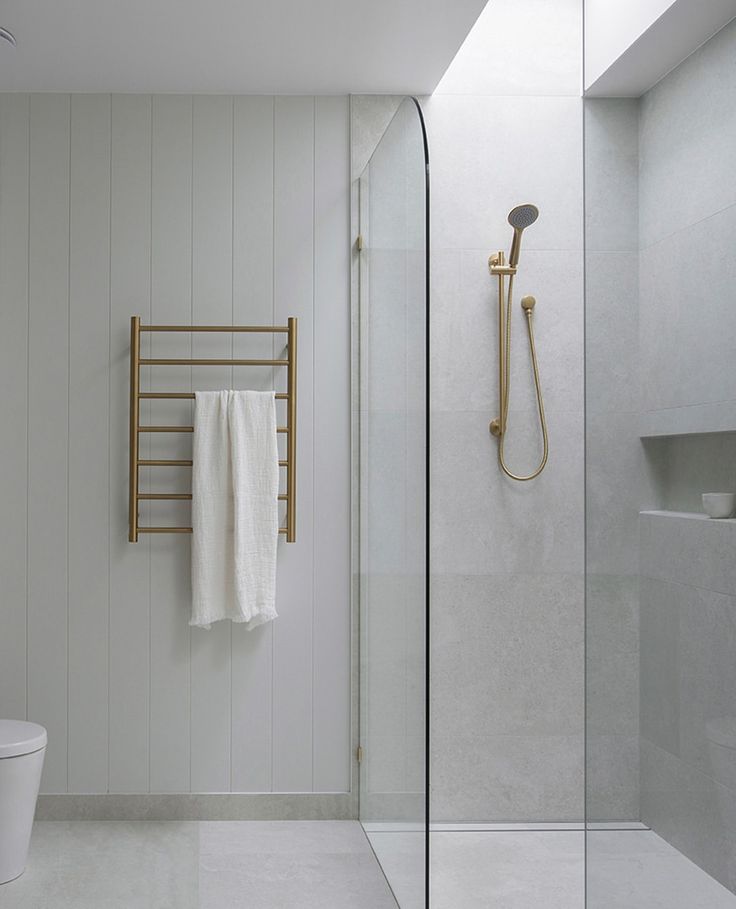 a bathroom with a toilet, shower and towel rack