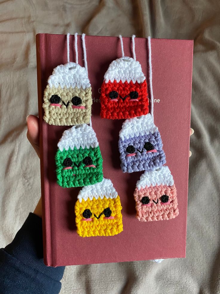 the book is decorated with crochet and has four small ornaments hanging from it