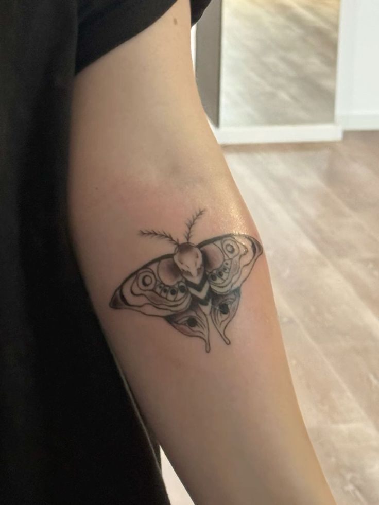 a woman's arm with a butterfly tattoo on the left side of her body