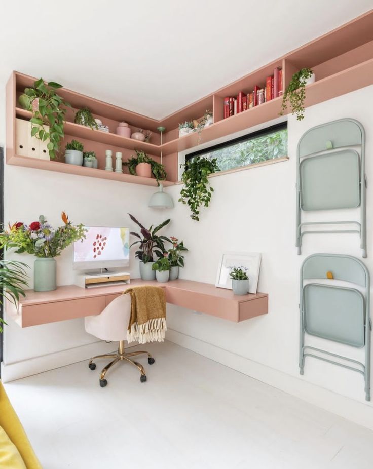 a desk with some plants on top of it and a chair in front of it