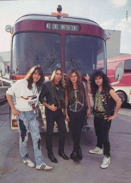 four people standing in front of a bus