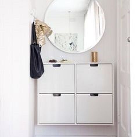 a white dresser sitting next to a mirror on top of a wall