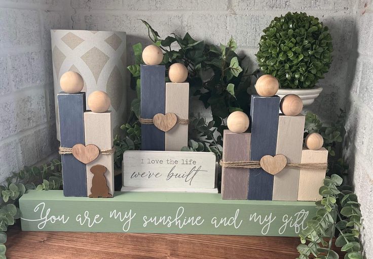 some wooden blocks with hearts on them are sitting in front of a potted plant