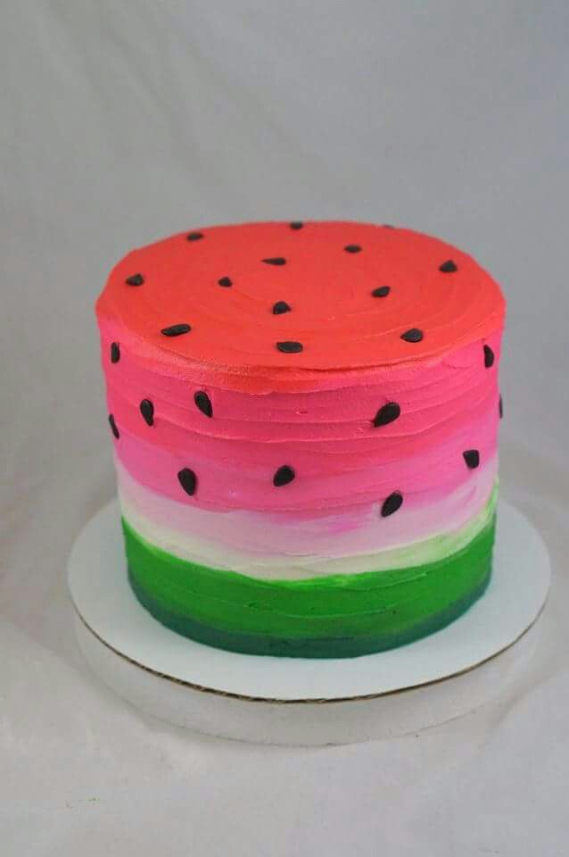 a cake with watermelon and black dots on it sitting on a white plate