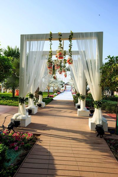 an outdoor ceremony with white drapes and flowers