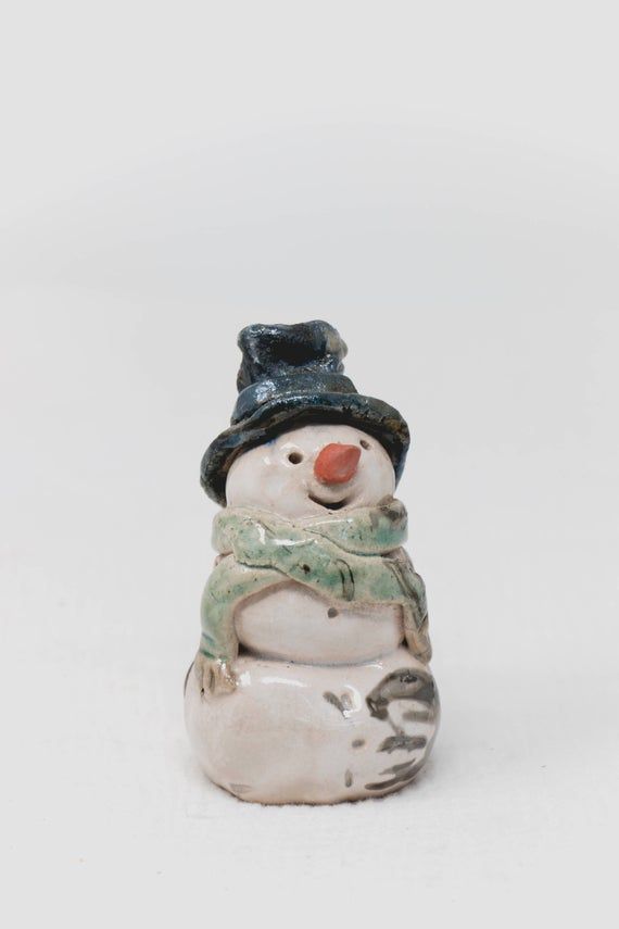 a ceramic snowman with a hat and scarf