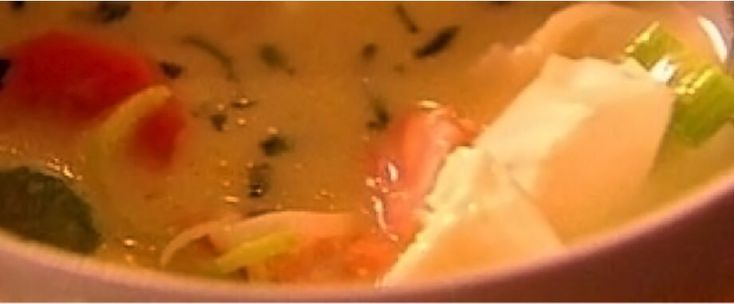 a bowl filled with soup and vegetables on top of a table