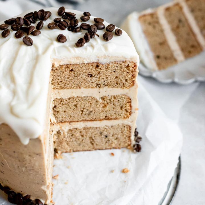 a slice of cake with white frosting and coffee beans on top