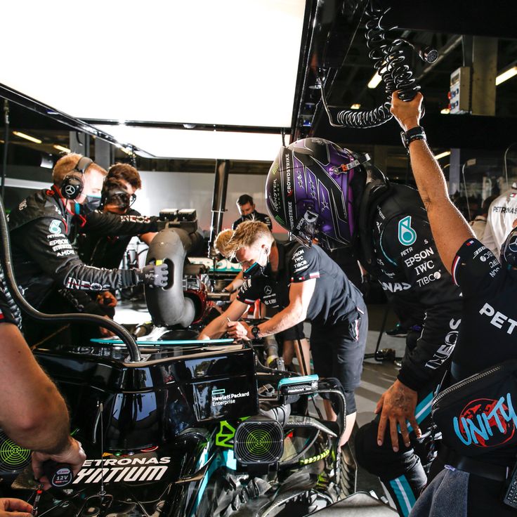 a group of men working on motorcycles in a garage