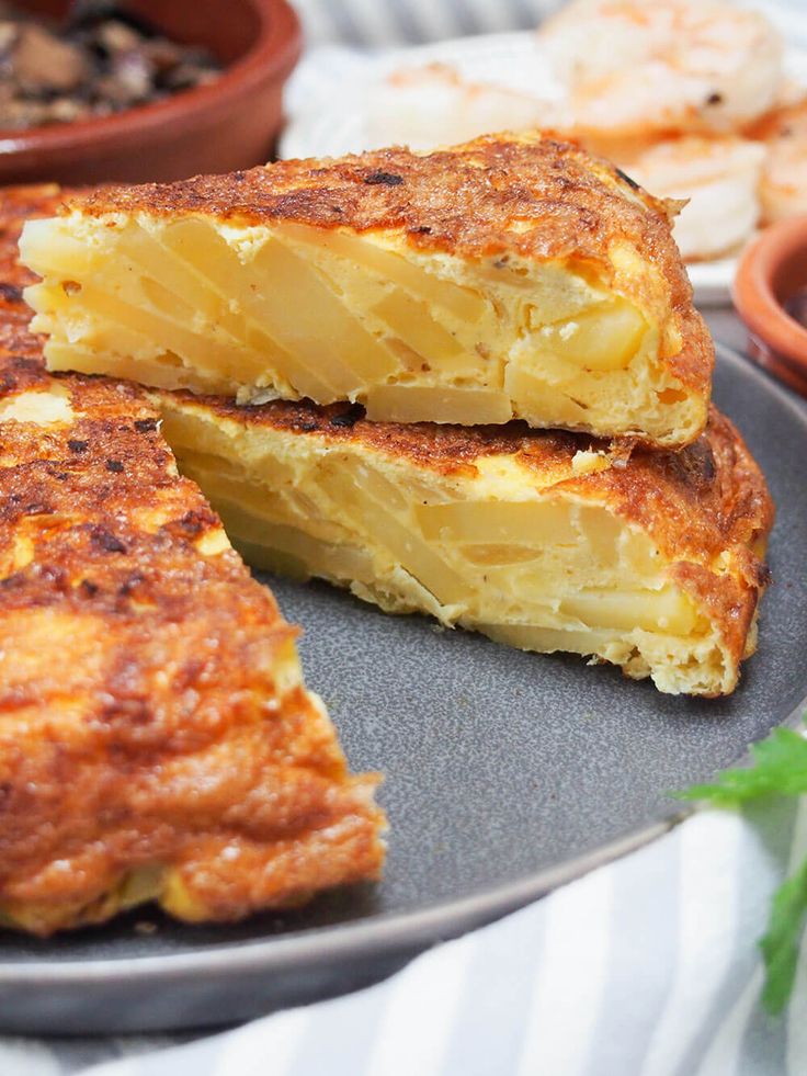 two pieces of french toast on a plate next to some other food items and bowls