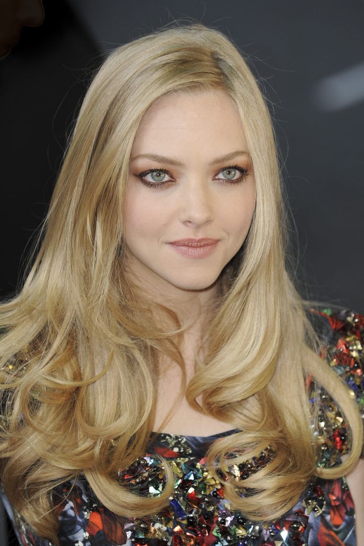 a woman with long blonde hair and blue eyes is posing for the camera at an event