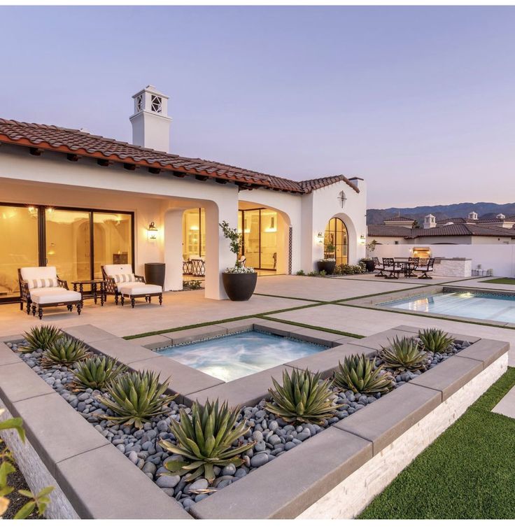 a house with a pool in the yard and patio area next to it at dusk