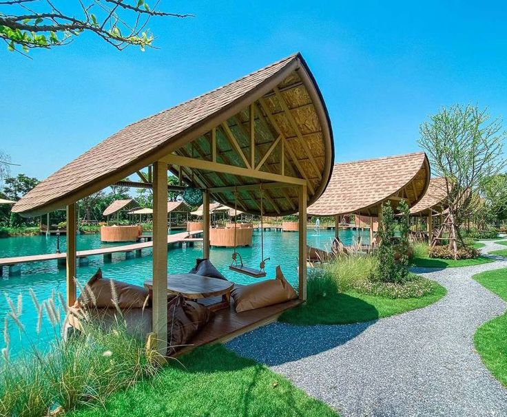 a gazebo sitting on top of a lush green field next to a body of water