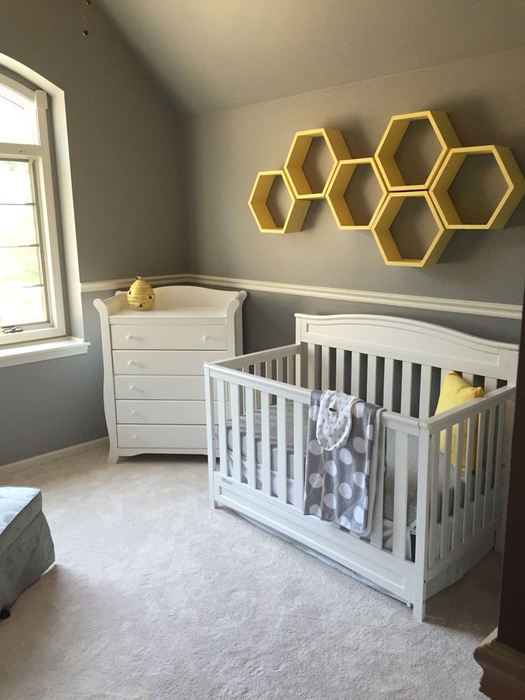 a baby's room with gray walls and white furniture