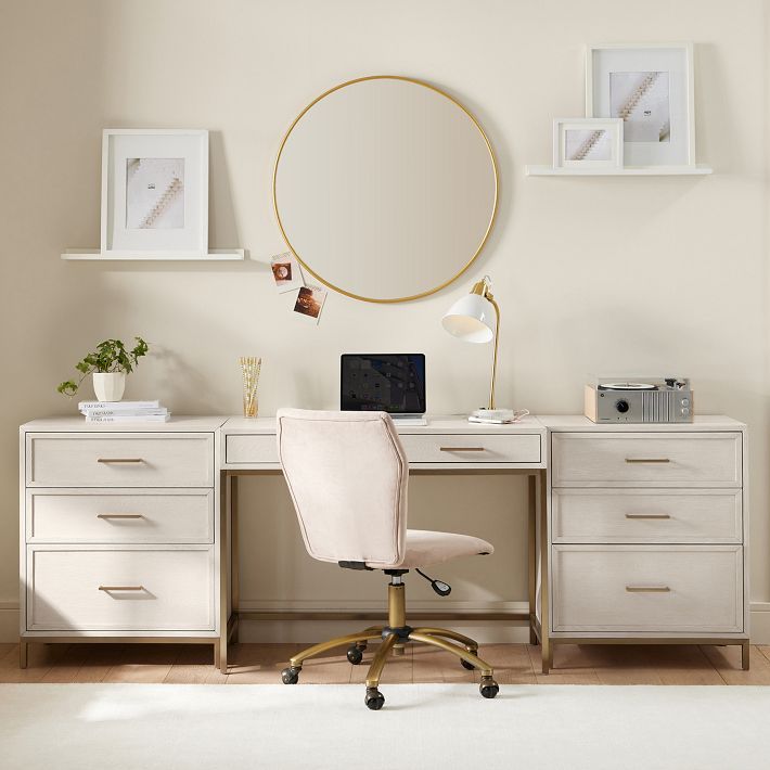 a white desk topped with a laptop computer next to a chair and framed pictures on the wall