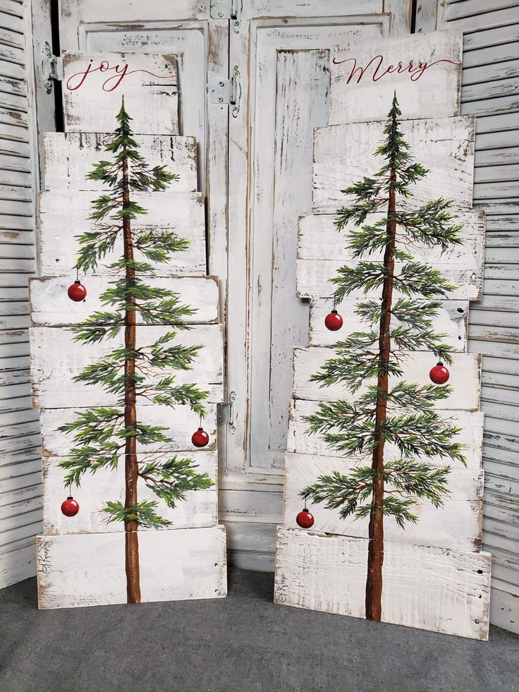 two wooden boards with christmas trees painted on them