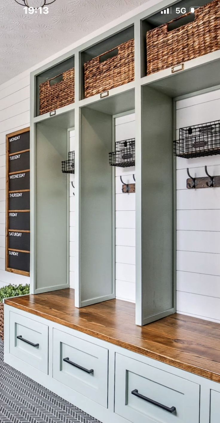 an organized mud room with baskets and bins