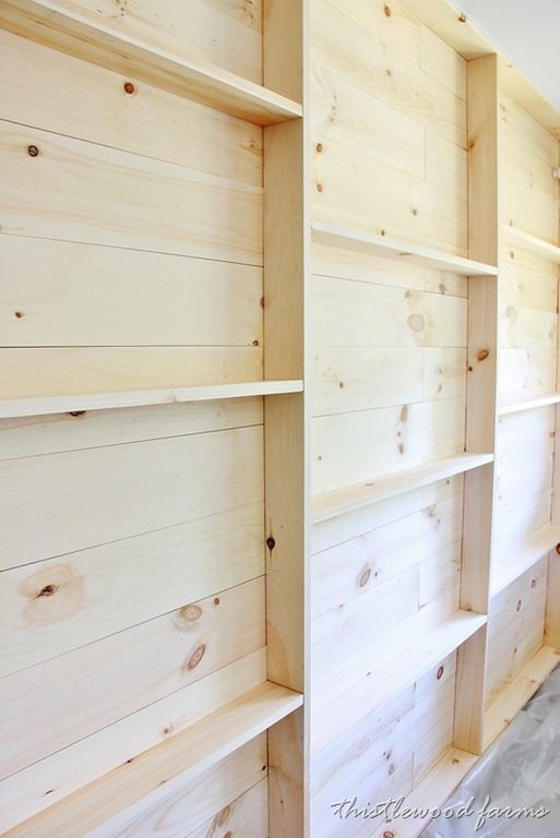 empty wooden shelves in a room with white walls