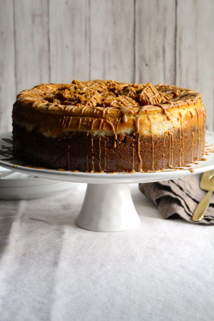 a cake with caramel drizzle on top is sitting on a white plate