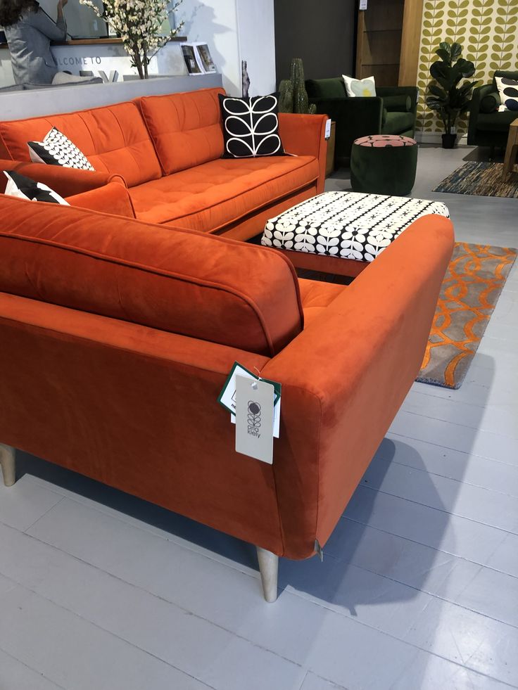 an orange couch sitting on top of a white floor