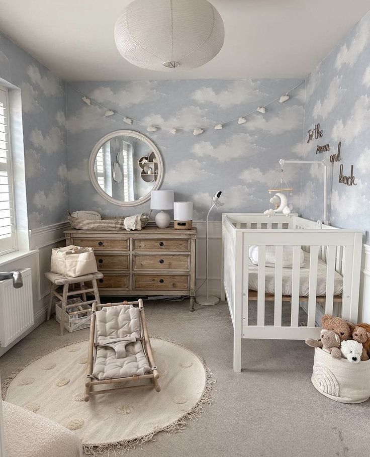 a baby's room with clouds painted on the wall