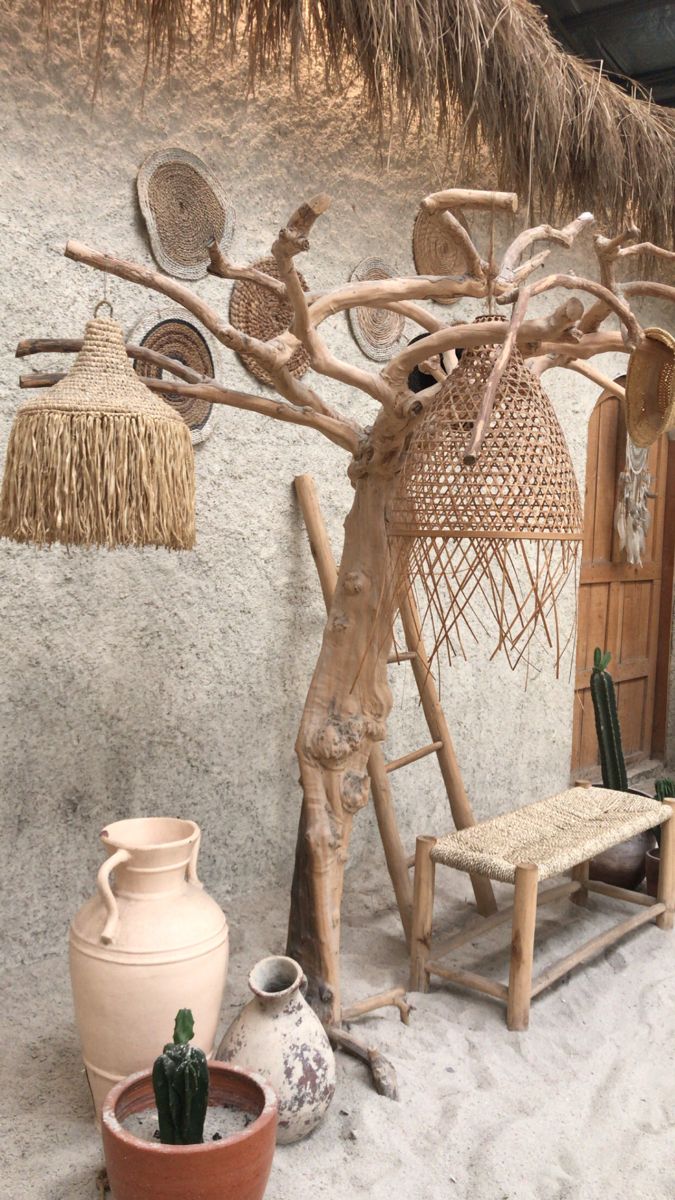 a wooden sculpture sitting next to a potted plant on top of a white floor