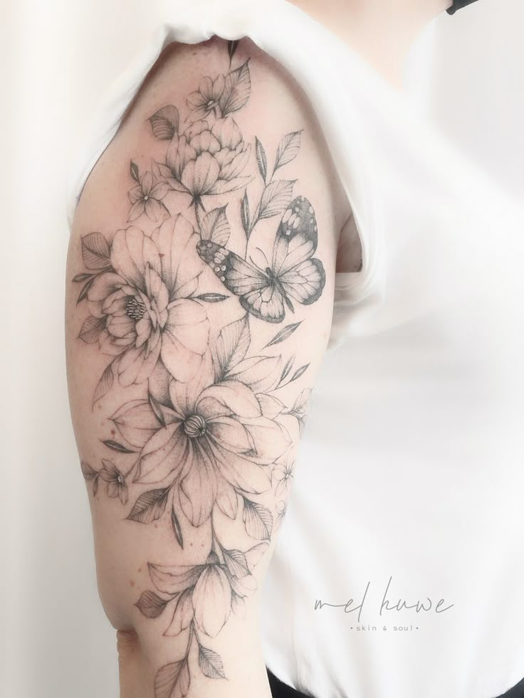 a woman's arm with flowers and butterflies on it