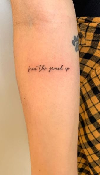 a person with a tattoo on their arm that says, don't the ground up