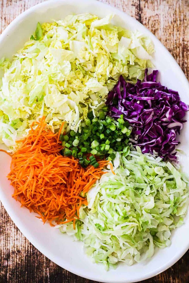 a white bowl filled with chopped vegetables on top of a wooden table