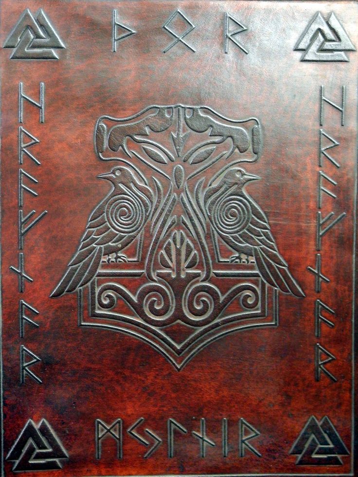 a leather book with an eagle on the front and two different symbols in the middle