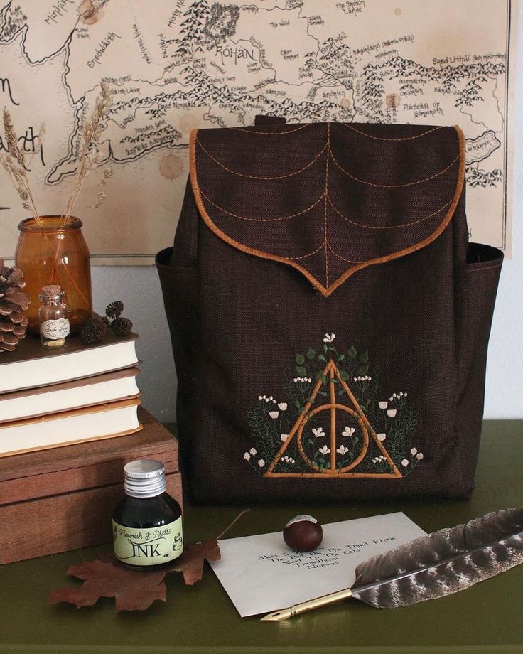 a harry potter bag sitting on top of a table next to books and an ink pen