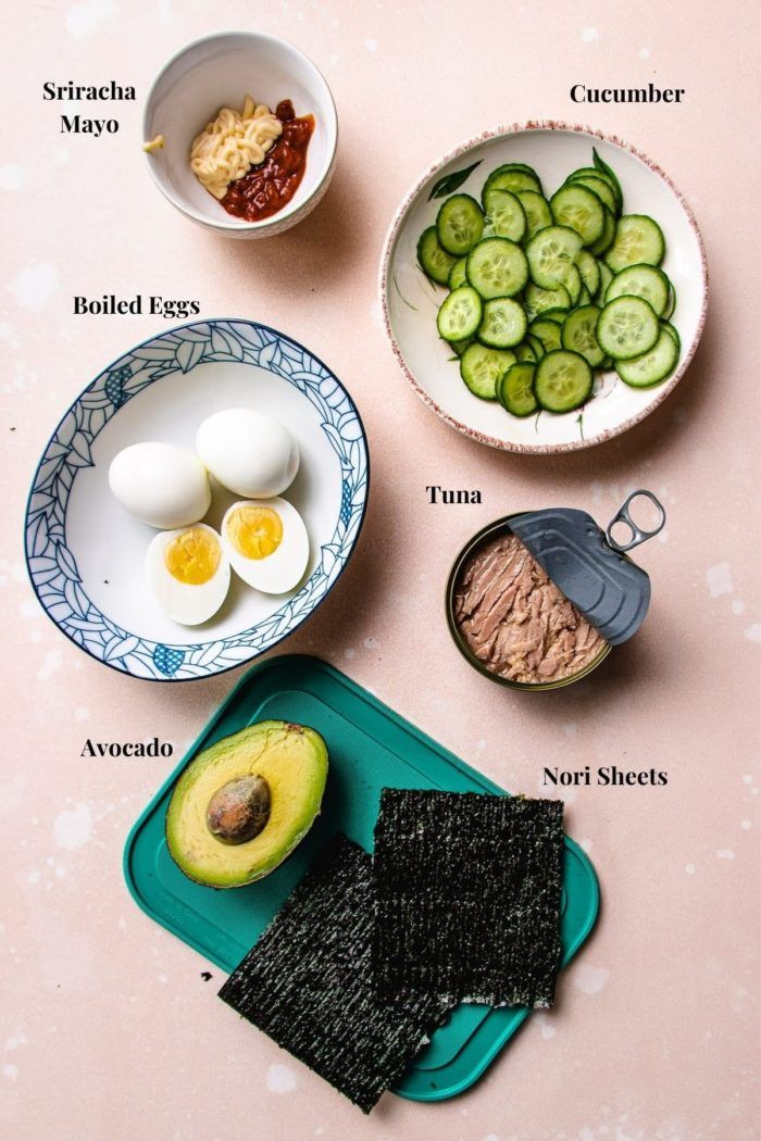 the ingredients to make an egg salad laid out on a pink surface