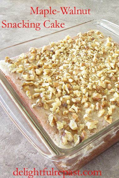 a glass baking dish filled with food on top of a gray counter next to an apple - walnut snack