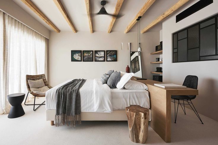 a bedroom with white walls and wooden beams