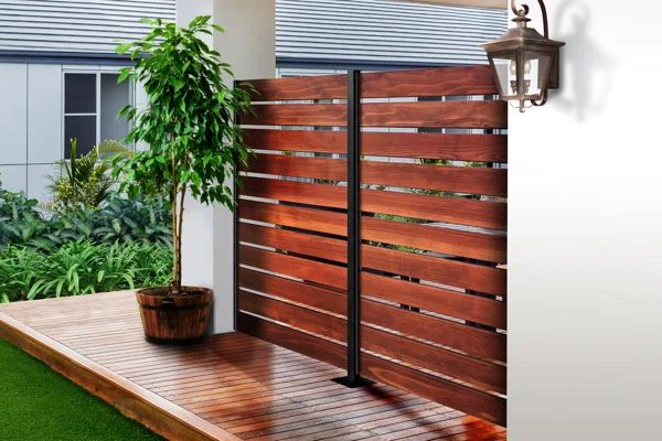 a wooden fence next to a potted plant on top of a grass covered deck