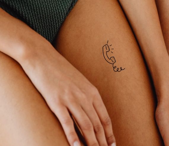 a close up of a person with a tattoo on their thigh