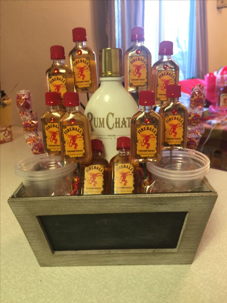 bottles of rum and other liquor sit in a metal container on a table with candy