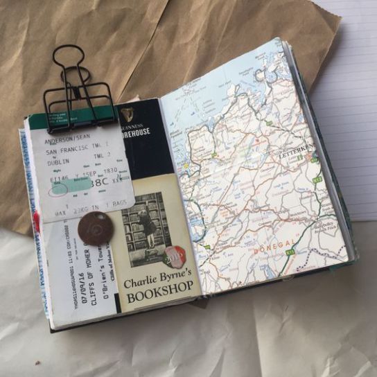 an open book sitting on top of a table next to a piece of paper and a clipboard