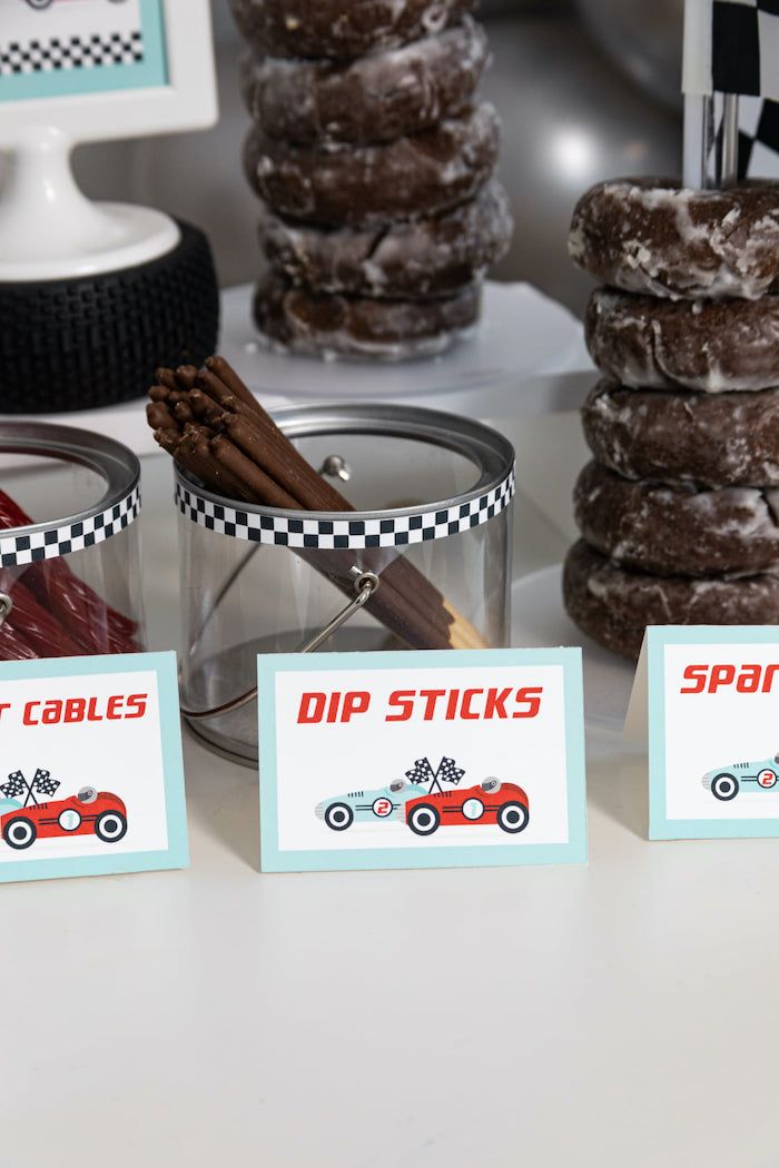 a table topped with donuts covered in frosting and toppings next to cupcakes