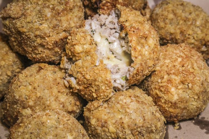 some food is sitting in a box on the table and it looks like they are made from meatballs