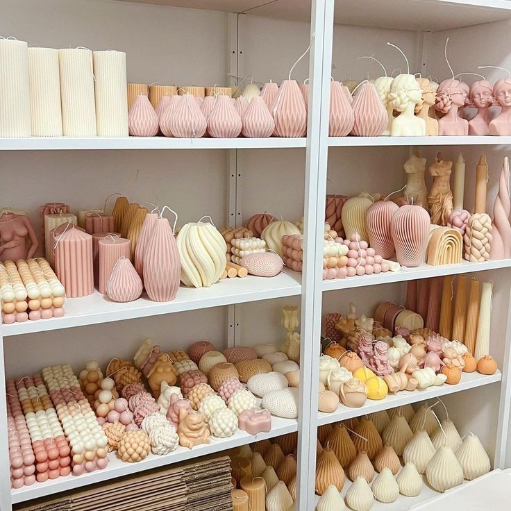 shelves filled with lots of different types of cakes and candies on white shelving